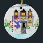 Snowman et Cosy House Ornement en céramique<br><div class="desc">Répandez de la joie avec ce bonhomme de neige et de sucre de canne devant cette maison de vacances ludique et poussiéreuse de neige avec des arbres et même une couronne à la porte. Un design fantasque pour l'arbre. Customisez comme vous le souhaitez.</div>