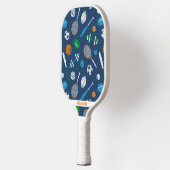 Sportuitrusting op donkerblauw pickleball paddle (Links)