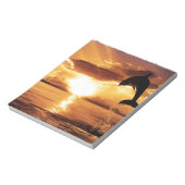 springdolfijn met prachtige zonsondergang over het notitieblok (Gedraaid)