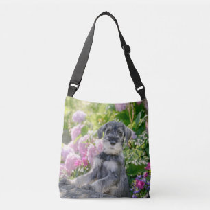 Standard Schnauzer Puppy in een bloeiende tuin - Crossbody Tas