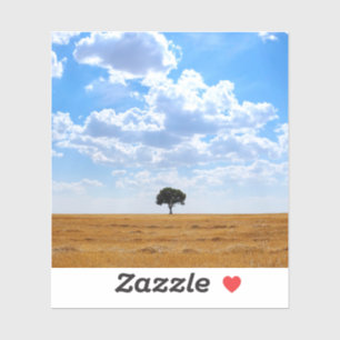 Sticker Arbre dans un champ de blé récolté