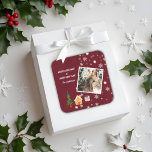 Sticker Carré Joyeux Noël Ruby Vin Famille Photo<br><div class="desc">Cet autocollant photo de vacances présente un message classique avec une forme d'arbre de Noël amusant, maison en pain d'épice et présente sur un magnifique arrière - plan de vin de rubis, radiant et plein d'énergie. Avec une photo à l'avant entourée de flocons de neige (amovible), c'est une excellente façon...</div>