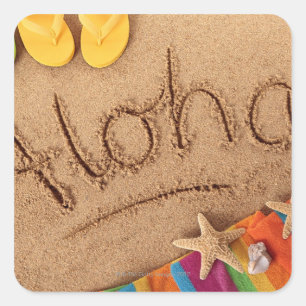 Sticker Carré Le mot Aloha écrit sur une plage de sable, avec 2