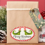 Sticker Ovale Jolly Christmas Elf Legs Vacances OVAL<br><div class="desc">Pieds elfes amusants portant des collants rayés rouge et ivoire et des bottes vertes avec des cloches de jingle, et vos détails de Noël de vacances en lettres chic, ces autocollants OVAL sont beaux pour les faveurs de fête, les cadeaux, les enveloppes d'invitation, les cadeaux alimentaires faits maison et plus...</div>