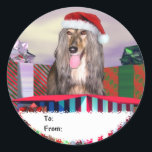 Sticker Rond Afghan Hound Christmas Surprise Tags cadeaux<br><div class="desc">Partagez une surprise de vacances avec cette Hound afghane portant un chapeau de Père Noël sortant d'une énorme boîte cadeau. OEuvre de Noël des Danois-R-Us.</div>