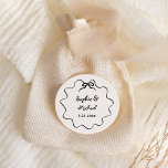 Sticker Rond Amour | Mariage français illustré<br><div class="desc">Cet autocollant chic et élégant de faveur de mariage présente un cadre dessiné à la main,  un cadre ondulé avec un arc,  et une écriture manuscrite stylisée pour un faire-part de mariage de style parisien ou français. Cette option de couleur classique est ivoire et noir.</div>