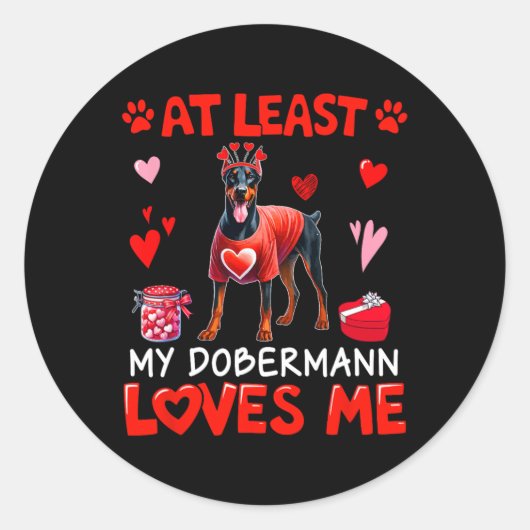 Sticker Rond Au moins mon Dobermann m'aimant la Saint-Valentin (Devant)