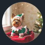 Sticker Rond Christmas Yorkie<br><div class="desc">adorable Yorkie de Noël habillé comme un elfe ! Tenue verte et blanche et un arbre de noël dans l'arrière - plan. Parfait pour vos cadeaux de chiot ou toute personne qui aime Yorkies!</div>