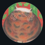 sticker rond de Christmas Pud<br><div class="desc">Un heureux chat tortue (qui ressemble à un pudding de Noël !) s'assied sur un coussin vert contre un arrière - plan de feuilles saintes rouges et vertes. Le design est personnalisable pour vous d'ajouter votre propre nom,  message et idées. Un dessin original au crayon coloré par Jess Perry.</div>