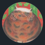 sticker rond de Christmas Pud<br><div class="desc">Un heureux chat tortue (qui ressemble à un pudding de Noël !) s'assied sur un coussin vert contre un arrière - plan de feuilles saintes rouges et vertes. Le design est personnalisable pour vous d'ajouter votre propre nom,  message et idées. Un dessin original au crayon coloré par Jess Perry.</div>