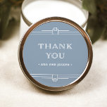 Sticker Rond Déco moderne | Elégant Mariage bleu et blanc Dusty<br><div class="desc">Ces stickers de mariage glamour ont une touche moderne sur l'art déco classique. Des bordures géométriques blanches et ornées décorent un élégant arrière - plan bleu poussiéreux pour un look de mariage spectaculaire et vintage. La typographie blanche classique dit "merci", ce qui les rend parfaits pour ajouter à vos faveurs...</div>