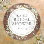 Sticker Rond Fête des mariées de verdure à cordes rustiques<br><div class="desc">Doté de jolies lampes à cordes et de délicats feuilles de verdure aquarelle sur un arrière - plan en bois rustique,  ce chic autocollant de douche à nuptiale botanique peut être personnalisé avec vos informations spéciales de douche à nuptiale. Conçu par Thisisnotme©</div>