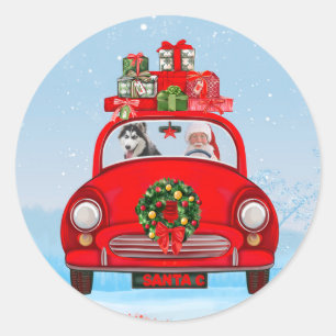 Sticker Rond Husky sibérien en voiture avec le Père Noël