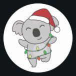 Sticker Rond Koala Christmas Winter Animaux Koalas Classic Roun<br><div class="desc">Le koala à Noël avec des lumières de fées. Animaux amusants avec des cadeaux et de la neige pour les vacances. Un doux salut de Noël. Les koalas sont des animaux mignons et parfaits pour Noël.</div>