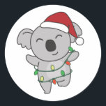 Sticker Rond Koala Christmas Winter Animaux Koalas Classic Roun<br><div class="desc">Le koala à Noël avec des lumières de fées. Animaux amusants avec des cadeaux et de la neige pour les vacances. Un doux salut de Noël. Les koalas sont des animaux mignons et parfaits pour Noël.</div>