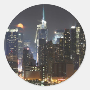 Sticker Rond La lune se lève au-dessus du Midtown New York.