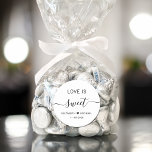 Sticker Rond L'Amour Est Un Mariage Sucré Faveur<br><div class="desc">Un sticker blanc chic pour votre dessert de réception de mariage et des faveurs de bonbons avec "L'amour est doux" dans une typographie moderne simple et un script élégant avec des swashes, vos prénoms unis par un coeur et votre date mariage.</div>