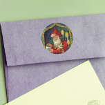 Sticker Rond Liste de Noël Vintage de Père Noël<br><div class="desc">Cette image vintage est un Père Noël à l'ancienne habillé de la tenue traditionnelle de cape rouge. Il vérifie sa liste avec des jouets en or. Il est entouré de bougies brillantes, encadrées de lierre avec un arrière - plan bleu étoilé. Voir mon magasin Art by MAR pour apparier les...</div>