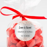 Sticker Rond Mariage argent rose noms or Love is Sweet<br><div class="desc">Un arrière - plan faux argenté. Personnalisez et ajoutez vos noms et la date du mariage. Texte : L'amour est doux. Décoré de confettis d'or rose. Pour les faveurs sucrées comme le chocolat,  les biscuits.</div>