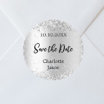 Sticker Rond Mariage du script en argent Enregistrer la date<br><div class="desc">Un autocollant Enregistrer la date pour votre mariage. Un arrière - plan faux argenté,  du texte noir. Décoré de confettis. Personnalisez et ajoutez vos noms et votre date de mariage.</div>
