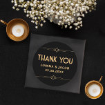 Sticker Rond Merci Art déco moderne Mariage noir et or<br><div class="desc">L'Autocollant rond Mariage classique Art déco moderne Noir et Or est la façon parfaite de vous remercier avec style. Il présente un élégant arrière - plan noir et d'élégants accents géométriques dorés. Idéal pour sceller des enveloppes ou ajouter une touche personnelle à vos préférences, cet autocollant capture le raffinement du...</div>