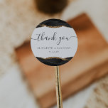 Sticker Rond Merci de Mariage d'âge d'or noir<br><div class="desc">Cet élégant autocollant mariage moderne présente une aquarelle noire géode d'agate décorée avec une parties scintillant en faux or. Les mots "merci" apparaissent dans la calligraphie manuscrite avec des swashes au début et à la fin. Ajoutez les noms du couple et la date du mariage ci-dessous.</div>