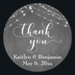 Sticker Rond Merci de script Mariage Chalkboard & White Lights<br><div class="desc">Avec un arrière - plan de tableau de bord texturé et deux cordes d'accents lumineux scintillants, j'ai combiné une police de script élaborée et moderne pour rendre des graphiques représentant des mots clés et des phrases dans l'ensemble de conception. Dans cet autocollant, la calligraphie dit "merci". Cette jolie collection design...</div>