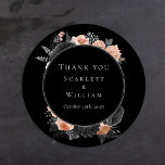 Sticker Rond Merci Mariage Vintage noir gothique<br><div class="desc">Cet autocollant vintage gothique mariage noir vous remercie classique rond est une toile sombre de romantisme et d'élégance intemporelle. Ce design présente des motifs traditionnels entrelacés d'une esthétique maussade qui rappelle l'automne. Délicate aquarelle rose poussiéreuse et arrangements floraux sombres et blondis dansent à travers la toile noire, évoquant la beauté...</div>