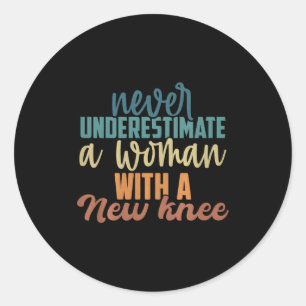 Sticker Rond Ne sous-estimez jamais une femme avec une nouvelle