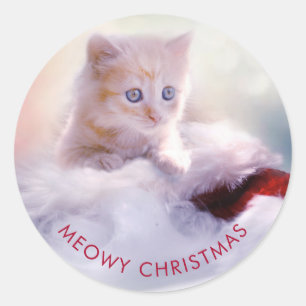 Sticker Rond Petit Kitten reposant sur un chapeau de Noël Meowy