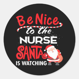 Sticker Rond Soyez gentil avec l'infirmière Père Noël regarde N