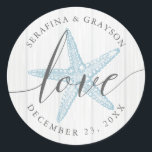 Sticker Rond Starfish Love Rustic Wood Blue Beach Wedding Favor<br><div class="desc">Sticker Rustic Beach Wedding Favor ou Envelope Sceau avec des noms et date mariage et le mot "amour" dans un élégant script de calligraphie écrit à la main sur un arrière - plan en bois gris clair avec illustration de perwinkle bleu vintage étoile de mer.</div>