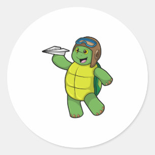 Sticker Rond Tortue comme pilote avec avion en papier