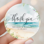 Sticker Rond Watercolor Beach Wedding Merci<br><div class="desc">Aquarelle Beach Mariage Merci Classic Round Sticker. Ce design présente une belle aquarelle scène de plage d'été. Ondes d'océan,  sable et fleurs sont tous représentés dans ce design tropical.</div>