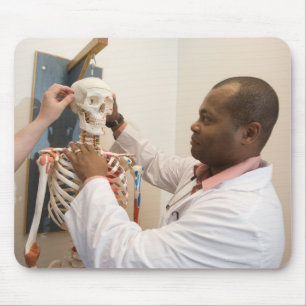 Studentenartsen bestuderen anatomie op een skelet muismat