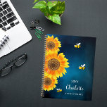 Sunflowers abeilles jaunes bleu nom du ciel<br><div class="desc">Préparez-vous à organiser vos journées avec une touche de charme naturel grâce à notre planificateur personnalisé de tournesol et de spirale d'abeille. Ce somptueux planificateur est orné d'un arrière - plan de ciel bleu foncé et serein, de tournesols colorés à l'eau et d'abeilles souriantes joyeuses, apportant un sentiment de joie...</div>