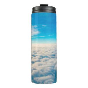 Sunrise boven wolken uit het raam van het vliegtui thermosbeker