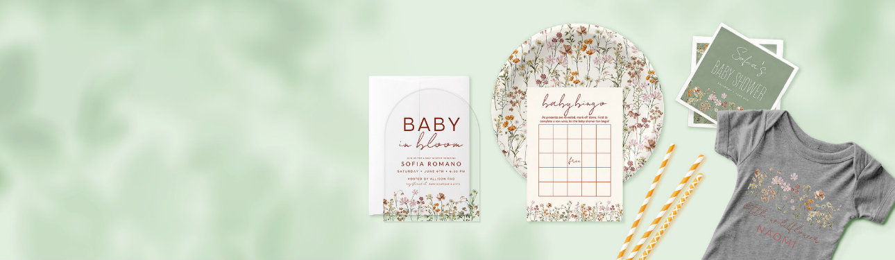 A spread of baby shower related products, all available on Zazzle. This includes an acrylic arched invitation, a paper plate, a baby bingo game, paper napkins, and a baby bodysuit, all in the theme "baby in bloom".