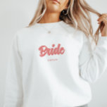 Sweatshirt Mariage personnalisé Rose 'Mariée' Enterrement de<br><div class="desc">Chemise à personnaliser avec le nom de la mariée sous 'Mariée' en lettres cursives roses. Cadeau idéal pour une fête de bachelorette ou une douche nuptiale.</div>