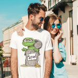 T-shirt En Tri-matière Oscar le mouvement du Groupement<br><div class="desc">Montrez votre amour pour Oscar le Grouch avec ce "Scram!" T-Shirt avec l'emblématique personnage de Sesame Street. Le design met en valeur le charme grincheux d'Oscar avec son texte audacieux et son expression célèbre,  ce qui en fait un choix amusant et ludique pour les fans de tous âges.</div>