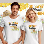 T-shirt Happ-Bee Birthday Bee Pun Bumblebee et Beehive<br><div class="desc">T-shirts d'anniversaire avec un jeu de mots personnalisé. L'inscription "happ-bee anniversaire [nom]" est décorée de bourdons, ruche et fleurs sauvages. Parfait pour les parents à porter à la fête d'anniversaire de leur petit-fils à thème d'abeilles ! Pour coordonner les invitations et le décor de fête, s'il vous plaît parcourez ma...</div>