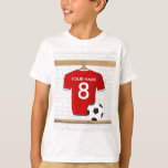 T-shirt Jersey de football rouge et blanc personnalisé<br><div class="desc">Un maillot de football personnalisé en rouge avec garniture blanche, accroché dans un vestiaire sportif avec une bouteille d'eau, des matchs de football et un ballon de football. Il suffit d'ajouter le nom et le numéro (ou l'âge) du joueur de football, du fan de football ou de l'entraîneur de l'équipe...</div>