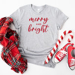 T-shirt Joyeux et brillant Noël des femmes rouges modernes<br><div class="desc">Un tee-shirt graphique festif pour les femmes avec une typographie en minuscules moderne avec "Joyeux et brillant". Le texte rouge et le style de t-shirt peuvent tous deux être modifiés.</div>