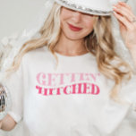 T-shirt Pink Cowgirl Gettin Hitte Bachelorette Party<br><div class="desc">Cette conception comporte un libellé rétro funky qui dit : Gettin' Hitched. Parfait pour célébrer la Dernière disco de la mariée ou le Dernier rodéo ! Voir la collection entière pour plus d'articles correspondants !</div>