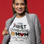 T-shirt Premier Noël en tant que mère - famille appariemen<br><div class="desc">Montrez votre joie pour votre tout premier Noël en tant que mère avec ce charmant t-shirt orné d'un chapeau de Père Noël rouge,  de feuilles verts,  d'une boule d'or,  d'un coeur rouge et de lumières de Noël colorées.</div>