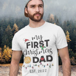 T-shirt Premier Noël en tant que père - famille appariemen<br><div class="desc">Montrez votre joie pour votre tout premier Noël en tant que père avec ce charmant t-shirt orné d'un chapeau de Père Noël rouge,  de feuilles verts,  d'une boule d'or,  d'un coeur rouge et de lumières de Noël colorées.</div>