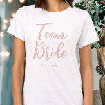 T-shirt Team Bride Mariage Personnalisé Rose<br><div class="desc">Célébrez votre équipe de mariées avec ce t-shirt mariage personnalisé ! Les mots 'Team Bride' sont écrits dans une police de script tendance, et ci-dessous vous pouvez ajouter un nom personnalisé, une date mariage, un emplacement ou un autre texte. Un beau cadeau pour une soirée bachelorette, un wedding shower ou...</div>