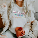 T-shirt TYRA 90's Theme Tropic Comme c'est Hot Bachelorett<br><div class="desc">Cette chemise de mariée à la bachelorette comporte une police néon sur le thème des années 90 avec les mots "tropique comme il fait chaud,  je suis en train de nouer". Cette chemise se marie parfaitement avec l'option "elle attache le noeud" de la bachelorette.</div>