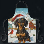 Tablier Dachshund Winter Wonderland Christmas Joy<br><div class="desc">Ce design festif reflète l'esprit joyeux de la période des fêtes, avec un adorable petit portant un chapeau de Père Noël. Le chien est niché dans un pays des merveilles hivernales, avec un bonhomme de neige, un sapin de Noël décoré et des cadeaux joliment emballés. Les flocons de neige tombent...</div>
