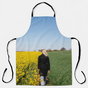 Tablier Femme en manteau noir debout sur un terrain d'herb